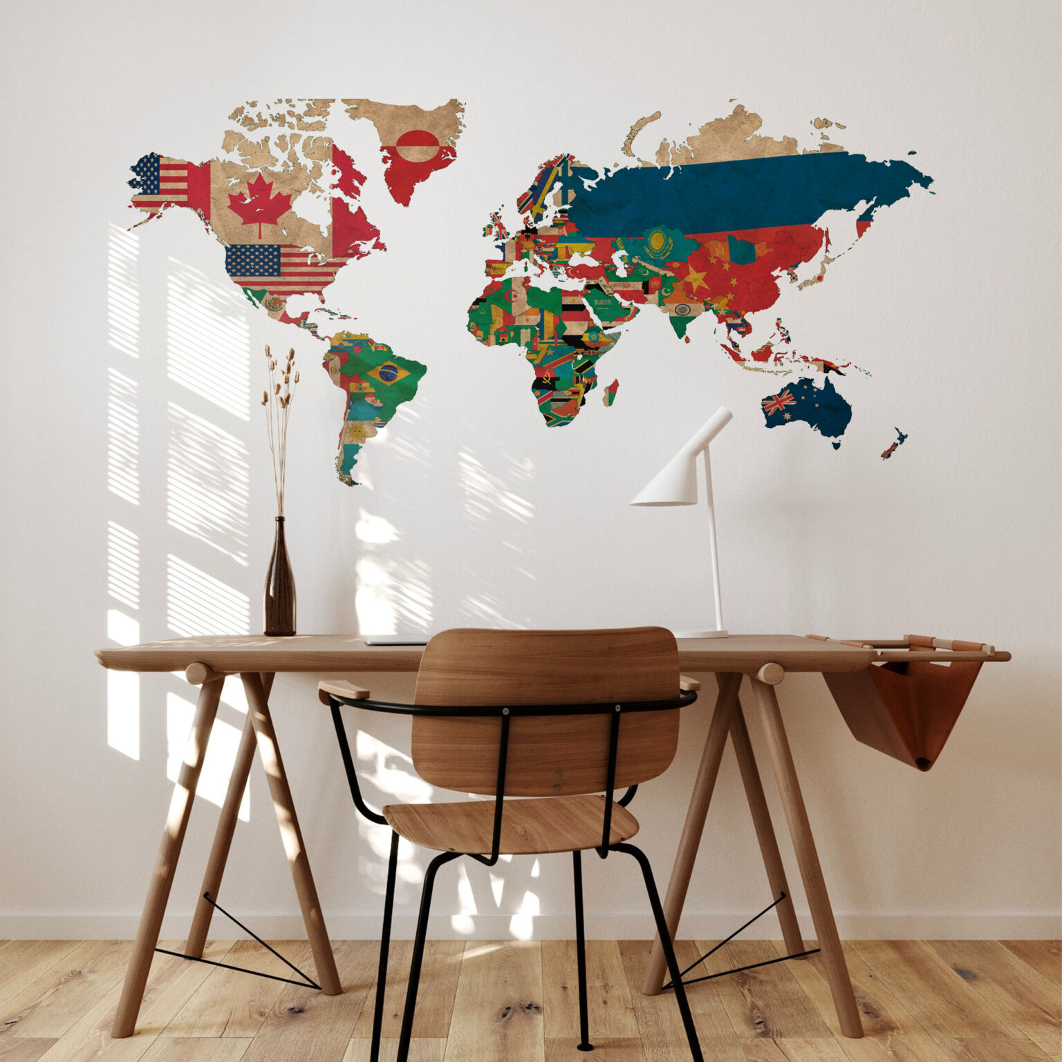 World map mural made from national flags on a wall above a wooden table and chairs in a bright room.