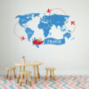 | Casadart | Vinis Autocolantes, Papel de Parede e Painéis Decorativos Blue world map wall mural with red airplanes circling and a kid-friendly table, pencils, and a chevron rug in a playroom.