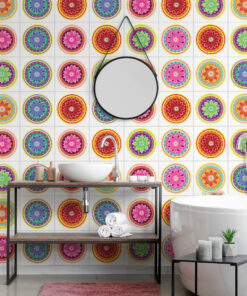 Modern bathroom featuring bright, circular mandala-patterned wall tiles, a white vessel sink on a metal shelf, and chrome fixtures with a pink rug on the floor.
