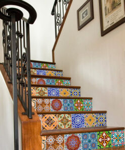 Indoor staircase with colorful tiled risers and a black wrought-iron railing in a home interior