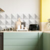 | Casadart | Vinis Autocolantes, Papel de Parede e Painéis Decorativos Modern kitchen counter with pastel green cabinets, geometric gray triangle backsplash, and a black toaster beside a wooden cutting board on a light wood counter.