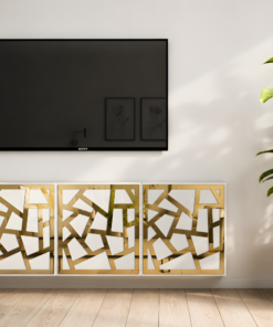 Wall-mounted black Sony flat-screen TV on a light wall, with a green plant to the right and gold-framed geometric art below on a cabinet.
