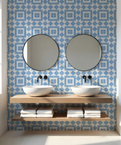 Symmetrical bathroom vanity with two round mirrors above white vessel sinks on a wooden shelf, blue geometric tiled wall.