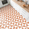 | Casadart | Vinis Autocolantes, Papel de Parede e Painéis Decorativos White kitchen cabinets with a wooden countertop and built-in oven on the left; orange-and-white geometric floor tiles visible down the room.