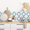 | Casadart | Vinis Autocolantes, Papel de Parede e Painéis Decorativos Kitchen counter with wooden cutting boards, a marble round board, and utensils against a blue geometric tile backsplash.