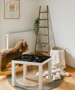 A small room with a large window | Casadart | Vinis Autocolantes, Papel de Parede e Painéis Decorativos Cozy child’s corner with a wooden ladder shelf, trailing plant, teddy bear on a rug, and a framed 'little star' illustration on the wall.