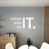 | Casadart | Vinis Autocolantes, Papel de Parede e Painéis Decorativos Office wall with large white letters reading 'DREAM IT WISH DO' on a gray backdrop, with a wooden cabinet and plant nearby.