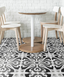 Modern cafe seating with white and wood chairs around a round marble-top table against a white brick wall.