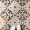 | Casadart | Vinis Autocolantes, Papel de Parede e Painéis Decorativos Decorative tiled floor in brown, beige, and white patterns with a person’s white sneakers visible at the bottom edge.
