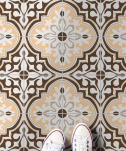Decorative tiled floor in brown, beige, and white patterns with a person’s white sneakers visible at the bottom edge.