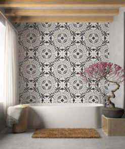 White freestanding bathtub in a contemporary bathroom with black-and-white patterned tile, exposed wooden beams, and a pink flowering tree.
