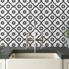 | Casadart | Vinis Autocolantes, Papel de Parede e Painéis Decorativos Chrome kitchen faucet over a white sink on a dark counter, with a bold black-and-white floral tile backsplash in the background.