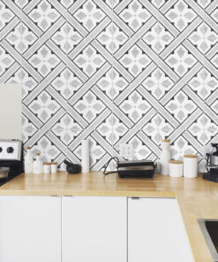 Kitchen counter with white cabinets, wooden worktop, and geometric black-and-white tiled backsplash in a modern kitchen setting