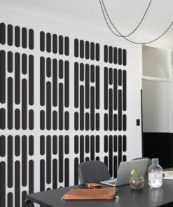 Modern conference room with a wall featuring vertical black rounded-rectangle pattern; table holds a laptop, notebook, water bottle, and glass.