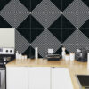 | Casadart | Vinis Autocolantes, Papel de Parede e Painéis Decorativos Kitchen counter with white cabinets and a bold black-and-white geometric tile backsplash; appliances visible (stovetop, jars, and coffee machine).
