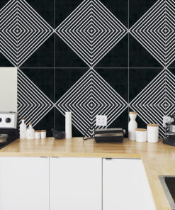 Kitchen counter with white cabinets and a bold black-and-white geometric tile backsplash; appliances visible (stovetop, jars, and coffee machine).