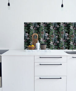 White kitchen with a tropical-pattern backsplash; counter features a cutting board, lemons, pepper mill, and a small plant.
