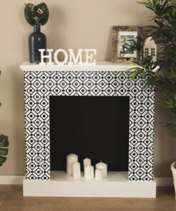Mantel decor with white letters spelling HOME, dark vase with leaves, a wooden frame photo, and greenery against a beige wall and black-and-white tiled surround.