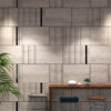 3d66com_775787-NS806-preto-2 | Casadart | Vinis Autocolantes, Papel de Parede e Painéis Decorativos Modern interior wall of beige stone tiles with black vertical lines; a wooden table with white bowls and a small plant in front of it.