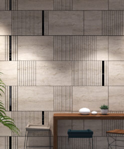 Modern interior wall of beige stone tiles with black vertical lines; a wooden table with white bowls and a small plant in front of it.
