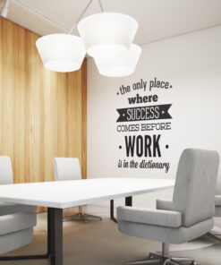 Conference room with a white table, gray chairs, wooden wall panels, and a wall quote: 'the only place where SUCCESS comes before WORK is in the dictionary'.