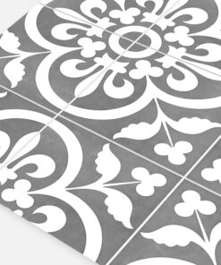 Close-up of decorative ceramic tiles with white floral motifs on a gray background.