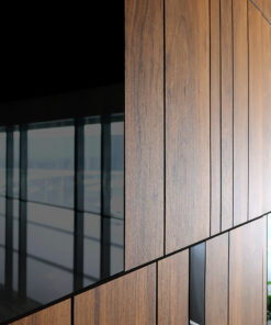 Close-up of vertical wooden slats on a modern building facade beside a glass window.