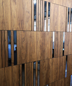 Wooden wall with vertical black glass slats creating a sparse, geometric pattern.