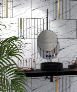 Modern bathroom wall with marble tiles, black grid lines, and gold vertical accents; circular concrete sink and black faucet visible with green plant in foreground.