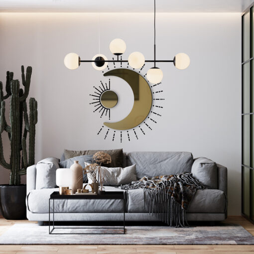 Modern living room with a gray sectional sofa, black metal coffee table, and a decorative wall sculpture featuring a gold crescent moon and sunburst design.