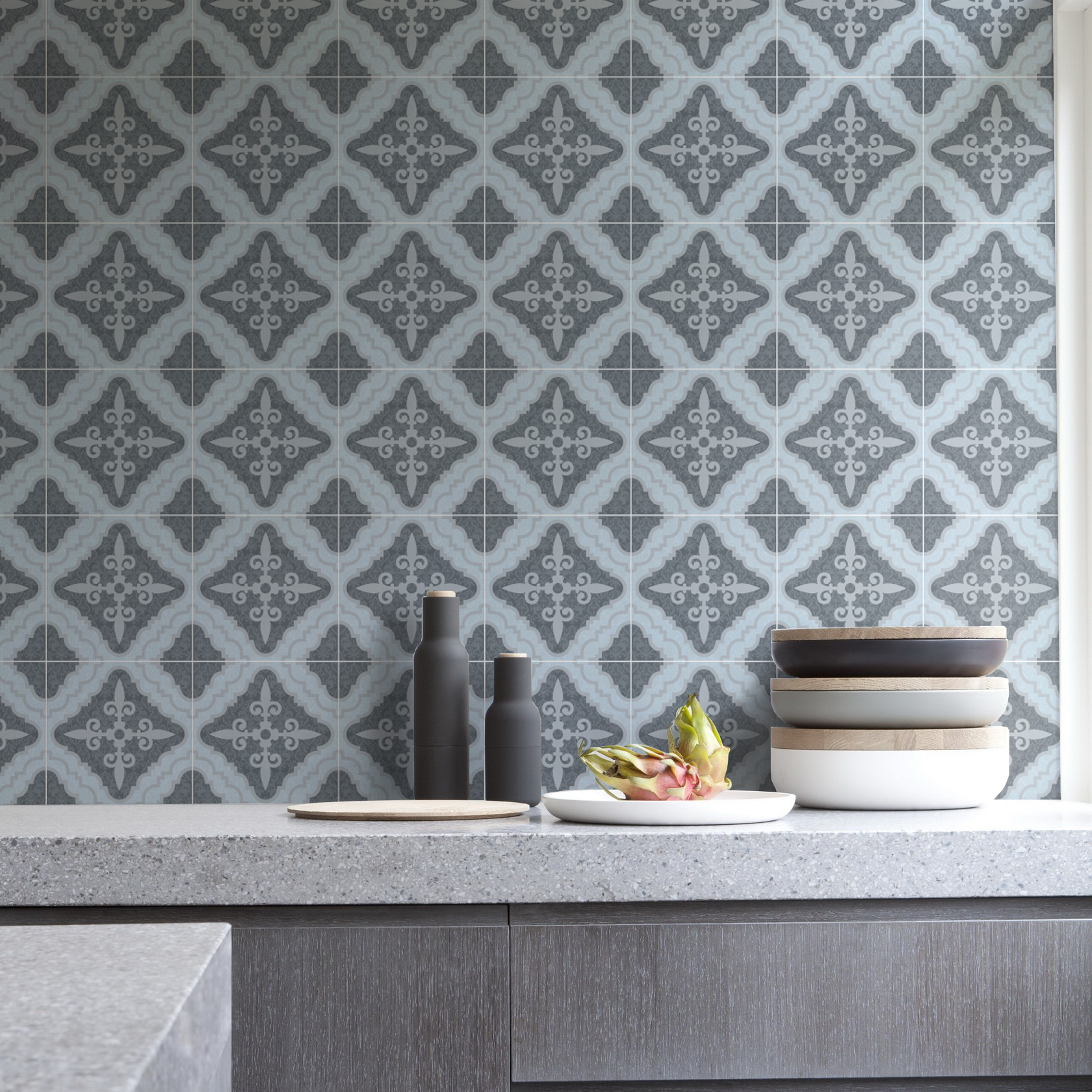 | Casadart | Vinis Autocolantes, Papel de Parede e Painéis Decorativos Kitchen backsplash with repeating gray decorative tiles, and a stone countertop with dark bottles and a small stack of bowls topped by a dragon fruit plate.