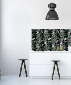 Modern kitchen corner with a tropical-patterned wallpaper panel, pendant light, white cabinets, and two wooden stools.