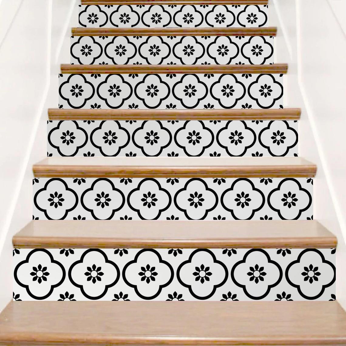 il_1140xN1656526691_8o8e | Casadart | Vinis Autocolantes, Papel de Parede e Painéis Decorativos Staircase with decorative black floral tile risers and natural wood treads in a bright space.