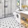 | Casadart | Vinis Autocolantes, Papel de Parede e Painéis Decorativos Modern white bathroom with a glass shower, black-and-white patterned floor, and a front-loading washing machine under a marble counter.