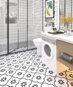 Modern white bathroom with a glass shower, black-and-white patterned floor, and a front-loading washing machine under a marble counter.