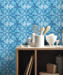 Wood kitchen counter with white canisters and utensils (whisk and wooden spoons) atop a blue geometric tiled wall, with shelves and storage below.