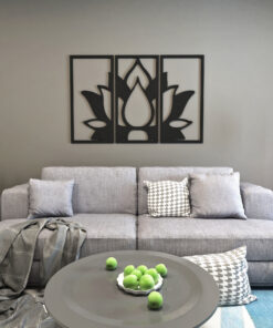 Gray sofa in a living room with three-panel black lotus wall art and a round coffee table with green apples on top.