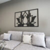 | Casadart | Vinis Autocolantes, Papel de Parede e Painéis Decorativos Gray fabric sofa with two patterned throw pillows and a blanket, against a wall with a three-panel botanical wall art piece.