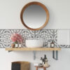 | Casadart | Vinis Autocolantes, Papel de Parede e Painéis Decorativos Round wooden-framed mirror above a white sink with patterned gray tile backsplash and assorted bottles on the counter area.