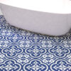 | Casadart | Vinis Autocolantes, Papel de Parede e Painéis Decorativos Blue and white decorative tiled floor with an intricate repeating pattern and a curved white surface overlapping the tiles.