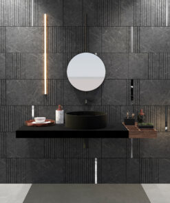 Modern bathroom display with dark marble tiles, a round mirror, vertical light bar, and a sleek black vanity.