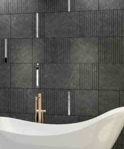 White freestanding bathtub with a gold faucet in a dark marble-tiled bathroom backdrop.